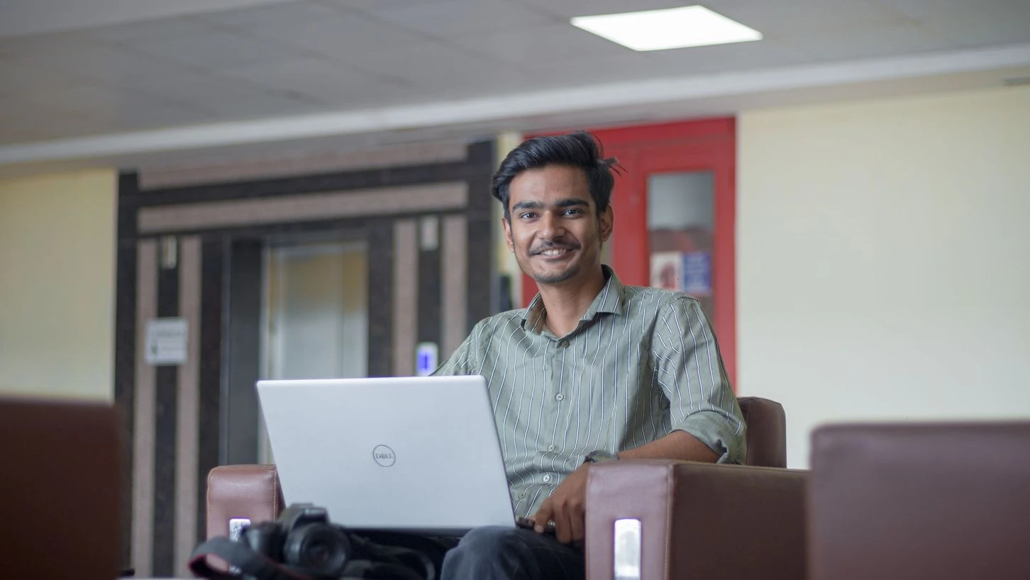 A young professional working on his laptop in an office in India