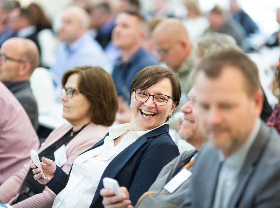 Group of diverse adults smiling and engaging during an indoor business meeting