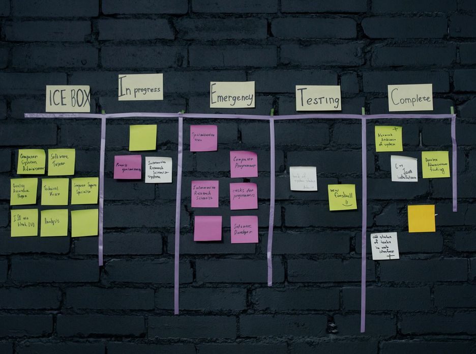 Top-down view of an office Kanban board with colorful sticky notes for task management and organization