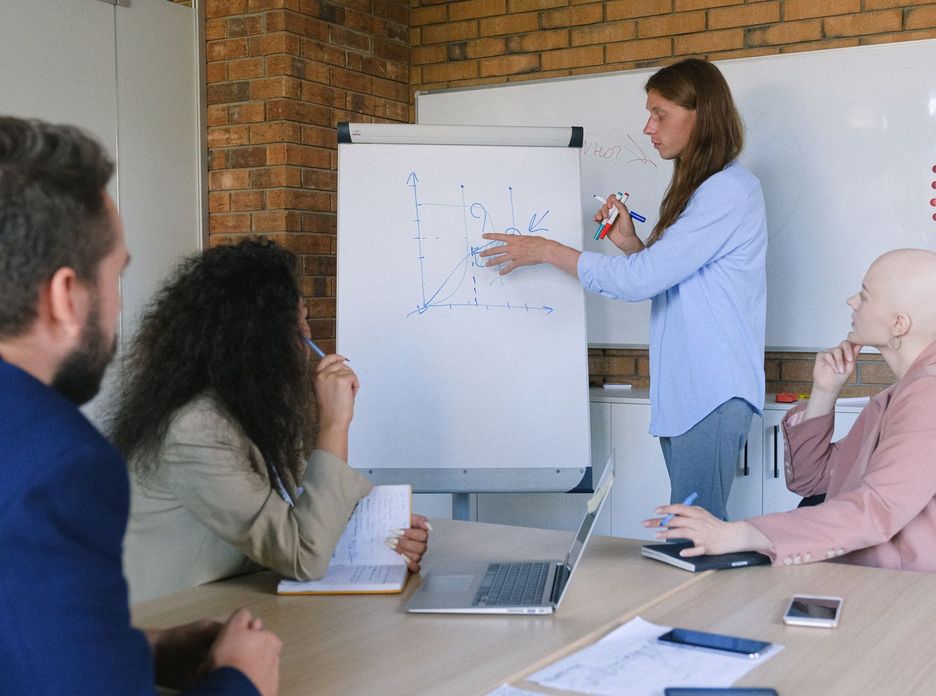 Group of pensive coworkers sitting at wooden table with gadgets and documents