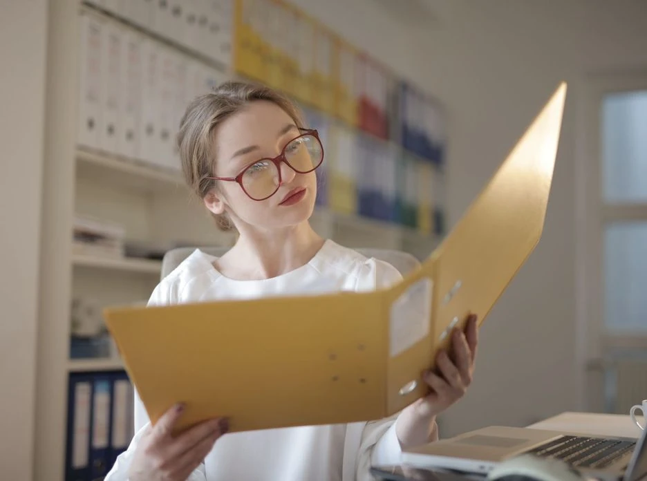Caucasian woman intensely reading documents in an office setting