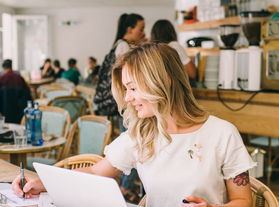A woman working on a laptop in a cafe
