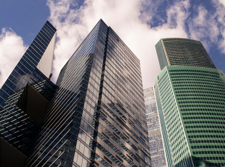 A dramatic view of Moscow's modern skyscrapers against a bright sky