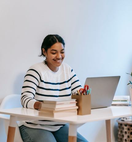 A woman working on a laptop at a table