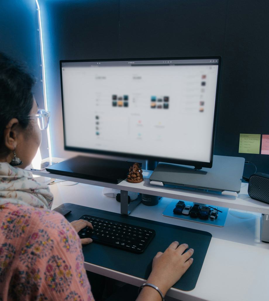A woman working at her desk, with a dashboard open on her computer screen